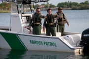 TEXAS, USA: Border Patrol agents point at a sign of activity on the Rio Grande, the river on the Texas-Mexico border. With heightened land enforcement fueling human smuggling by sea, the Border Patrol has had to introduce new boat models for the pursuit of high-speed vehicles.  (Photo Credit: © NGT)