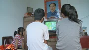 Chinesische Kinder beim Fernsehen - unter dem Porträt von Mao Zedong