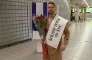 Jesse Meester waits with roses and a welcome home banner to meet his online girlfriend Darcey Silva in person for the first time.