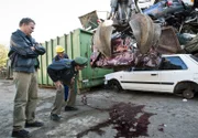 Hubert (Christian Tramitz, links) und Staller (Helmfried von Lüttichau) fällt auf, dass aus einem bereits verschrotteten Auto Blut fließt. Schrottplatzbetreiber Manfred Matuschik (Helmut Rühl, hinten) kann sich das nicht erklären.