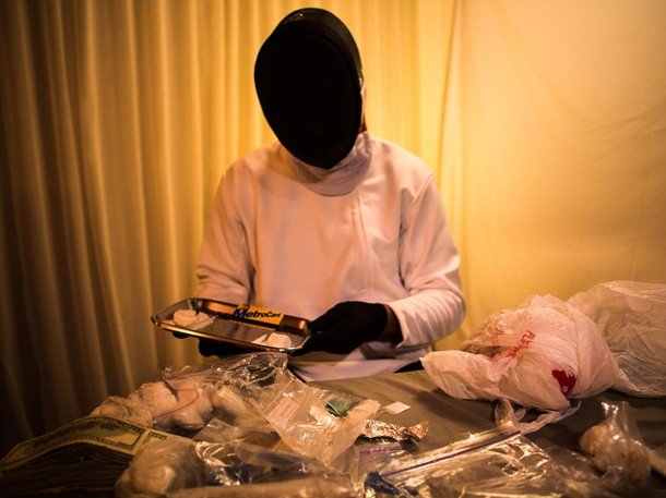 A masked NYC dealer with a tray of heroin. New York is America?s largest city, a huge distribution hub with an equally large appetite for narcotics.