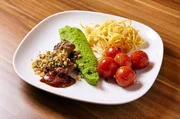 Die Hauptspeise: Schafrücken mit Brezel-Nuss Kruste, Erbsenpüree, geschmorte Cocktailtomaten
und Kartoffelstroh.