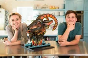 Portrait of Natalie Sideserf and GianPaolo Fiorino with the bacon-maple goat cake that they worked on together for Dave's surprise birthday party, as seen on Food Network's Texas Cake House.
