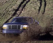 pickup truck in action, through a large puddle of mud.