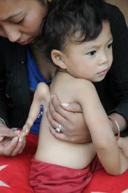 Close up of Gaurab Gurung sitting on his mother Kalpana Gurung lap.