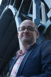 Moderator Prof. Mark Miodownik vor der ersten Eisenbrücke, die in England gebaut wurde.