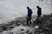 Caesar and Blake walk over snowy terrain.