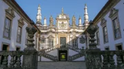 "Magische Gärten", "Mateuspalast - Portugal." Im Norden Portugals, unweit des Douro-Tals, liegt mitten in den Weinbergen die Casa de Mateus: der Mateuspalast. Hier vereinen sich landwirtschaftliche Flächen mit Schaugärten. So steht ein Barockpalais aus dem 18. Jahrhundert neben einem alten Waschhaus und einem Kornspeicher. Der Eingangsbereich zum Anwesen ist sehr theatralisch gestaltet: Beim Hereinkommen durchqueren Besucher zuerst ein Stück Wald, das die Sicht versperrt. Dann stehen sie plötzlich vor einem Wasserbecken, das mit dem Gebäude korrespondiert. Als Gonçalo Ribeiro Telles dieses Wasserbecken und den Eingangsbereich entwarf, rückte er den Palast in den Mittelpunkt. Durch die Alleen und den dichten Pflanzenbewuchs lenkte er die Aufmerksamkeit auf das Gebäude. Und durch die Spiegelung des Schlosses erzeugte er einen fast schon theatralischen Effekt, der die Besucher immer wieder fasziniert. Die Architektur, die Außenflächen und die Gärten wirken sehr stimmig, obwohl sie zu verschiedenen Zeiten entstanden sind. Der Palast ist ein herrschaftliches Gebäude in der bürgerlichen Architektur des 18. Jahrhunderts, während der Garten in einen neobarocken Stil angelegt wurde, der erst viel später in der zweiten Hälfte des 20. Jahrhunderts aufkam. Der Anschein, alles sei vor 300 Jahren entstanden, trügt also. Alte Elemente blieben jedoch über die Zeit und die Umgestaltung des Gartens erhalten. Anhand dieser den Epochen eigenen Elemente können heute die verschiedenen Epochen leicht unterschieden werden. Das macht den Garten des Mateuspalastes so wertvoll.