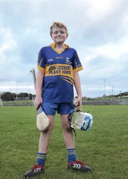 Mac mit seiner Hurling Ausrüstung: Helm, Hurl (Schläger) und Sliotar (Ball).