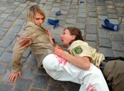 Beim Schußwechsel nach dem Banküberfall klammert sich die sterbende 
Polizistin (Annett El-Chanati) an die Augenzeugin Jenny (Nadeshda Brennicke).