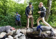 Der Passant (Roberto Martinez, links) führt Hubert (Christian Tramitz, rechts) und Staller (Helmfried von Lüttichau) zu dem Krokodil. Hubert wirft einen Stein um zu testen, ob der Kaiman noch lebt. Da entdecken sie, dass neben dem Kaiman der tote Tobias Brunner (Komparse) liegt.