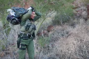 Nogales, AZ: An agent carrying a confiscated bundle on his back. Some migrants act as drug mules, carrying loads of illegal drugs across the border where they will be picked up by drug vendors.