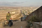 SAN DIEGO, CA, USA: A border patrol agent on an ATV surveys the international boundary that separates San Diego from Tijuana. This San Ysidro border crossing is the busiest in the world, with over 40 million people entering the U.S. through this port in 2005 alone.