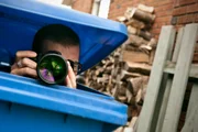 hiding in a blue garbage bin to take pictures