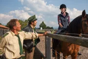 Hubert (Christian Tramitz, l.) und Staller (Helmfried von Lüttichau, M.) kommen zum Reitplatz und wenden sich an die Reiterin Kathi Jung (Julia Nalbach, r.) und berichten ihr, dass eine Beschwerde vorliegt. Bauer Pauli hat sie angezeigt, weil sie immer mit den Pferden über seine Wiese reiten und das Gras kaputt mache.