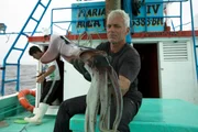 Jeremy Wade on a fishing boat in Peru off the coast of Paita holding a Humbolt Squid.