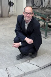 Moderator Prof. Mark Miodownik ist über eine dünne Platte gelaufen, um zu zeigen, wie leicht diese unter seinem Gewicht zerbricht.