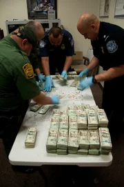 Laredo, TX: Customs and Border Protection agents counting confiscated money that was being smuggled to pay for the drug trade. 
(Photo Credit: © NGT)