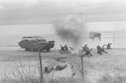 Picture shows_Drama reconstruction_Soldiers behind hedgehogs as explosions go off on the beach