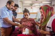 ANANTNAG, KASHMIR - JULY 05: Doctor Malik Azad checks Khalida Akhter, 18, after the surgery at the Mirza Mohd. Afzal Beigh Memorial Hospital or Government District Hospital on July 05, 2015 in Anantnag, Kashmir.  Doctors in Kashmir claim to have removed the world's biggest cyst - weighing a massive 48.5 lbs. The giant cyst, which weighed more than a five-year-old child, was removed from an 18-year-old patient Khalida Akhtar. Doctors removed the growth from the teenager’s ovary after Khalida arrived at the hospital complaining of discomfort and a severe abdominal pain.