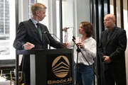 Kann Jenni (Anna Mennicken, M.) Olafs (Thomas Morris, l.) Machenschaften bei der Pressekonferenz unterbinden?