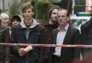 Hauptkommissar Andreas Keppler (Martin Wuttke, rechts) ist gerade in Leipzig angekommen und beobachtet von außen die Situation am Tatort. Auch Max Lornsen (Joseph Bundschuh, links) der zu den Jugendlichen gehört, die mit Hans Freytag ihre Freizeit gestaltet haben, betrachtet traurig die Szenerie.