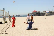 The group plays beach volleyball.