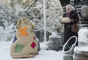 Beutolomäus (Alexis Krüger) und der Weihnachtsmann (Achim Wolff) finden vor ihrer Hütte ein Päckchen. Von einem Freund steht als Absender darauf.