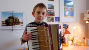 Der 7-jährige Maximilian spielt Akkordeon – oder Ziehharmonika oder Schifferklavier oder Handorgel oder Quetschkommode. Für das Akkordeon gibt es viele Namen. Auf der Sesamstraßen-Bühne präsentiert er sein Lieblingslied: Oh Susanna!
