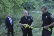 Police set up a crime scene after finding a dead body in a river.