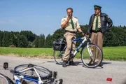 Staller (Helmfried von Lüttichau, rechts) hat das Fahrrad wutentbrannt auf die Straße geworfen, es hatte einen Platten. Hubert (Christian Tramitz, l.) meldet den "Todeszeitpunkt" des Fahrrads an die Zentrale.