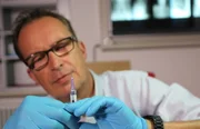 Medizinjournalist und Arzt Dr. Christoph Specht mit Impf-Spritze