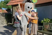 Lilly (Henriette Nagel), Lola (Lisanne Frontzek) und Lisa (Luise Töpfer) packen die gelieferte Alienpuppe aus dem Holzkasten aus.