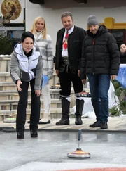 Verena Gotzler, Weltmeisterin im Eisstockschießen, zeigt Kiwi, Norbert Rier und Christian Neureuther den gekonnten Schuss.