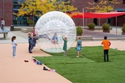 Die Kinder spielen mit dem Riesenball.