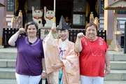 Beate (l.) und Irene (r.) lernen auf ihrer Reise in Tokio den japanischen Glücksbringer Winkekatze kennen.