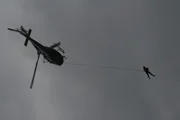 Bear Grylls tethered beneath helicopter with rope. 17641_Bear tethered beneath helicopter