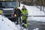 Odda, Norway - (Left to Right) Jarle Hauksland and Thord Paulsen. Jarle Hauksland is a local guy helping Thord to rescue the trash truck that has one of the wheels in the ditch. They are planning how to do the operation.