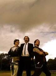 Hauptfigur Angelo Sommerfeld (Mitte) mit seinem Sohn Johnny (Jasper Barwasser, links) und Mitbewohner Oshi (Markus Hammer).