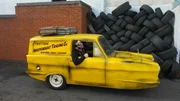 Episode 3. Auto. Jesse sitting in yellow Robin Reliant and sticking his head out window.