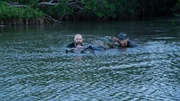 Jason and Jason guide the crocodile to shore.