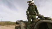 Nogales, AZ: An agent standing up on his ATV and looking back. ATVs are regularly used in the desert by Border Patrol agents because of their ability to cross difficult terrain.