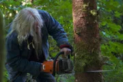 Billy Brown sawing a tree.