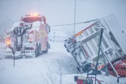 Overhalla, Norway - Total of truck that has tipped over. The truck in the ditch is attached to a wire that is connected to the towing truck. This is one of the elements that will help the truck up from the ditch. They are also using air-pillows to help it.