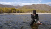 Thad Robison holds a fish he caught in Mongolia.