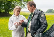 Hubert (Christian Tramitz, rechts) wurde von den Bienen in die Hand gestochen. Dr. Anja Licht (Karin Thaler) versorgt die Stiche mit einer Salbe.