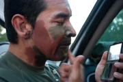 Laredo, TX: An agent painting his face in camouflage before a mission.