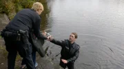 Beim Versuch, ein Buddelschiff aus dem Wasser zu fischen, ist Mattes selbst (Matthias Schloo) "über Bord" gegangen. Melanie Hansen (Sanna Englund) nimmt ihm das Buddelschiff ab.