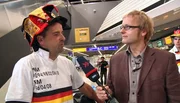 Kai Diezemann (re.) trifft Reisende am Frankfurter Flughafen: z. B. einen Fußballfan - vor dem entscheidenden WM-Spiel gegen Ghana fliegt dieser deutsche Fußballfan schnell noch nach Südafrika.