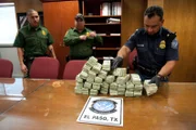 El Paso, TX: Officer Holguin and two agents counting a big pile of confiscated cash. Laundered money is one illegal item which is regularly smuggled across the border. This money would likely have been sent to a drug cartel.  
(Photo Credit: © NGT and Kevin Cunningham)